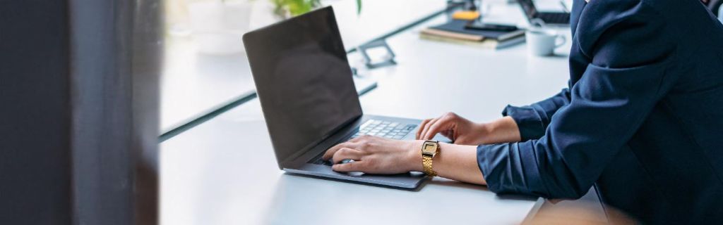Ung kvinde arbejder på en bærbar computer på et moderne kontor.