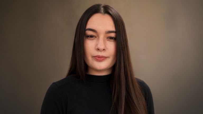 Daniela Moaca, Senior Manager IT hos EOS Romania, portrætfoto i en mørk turtleneck-sweater.