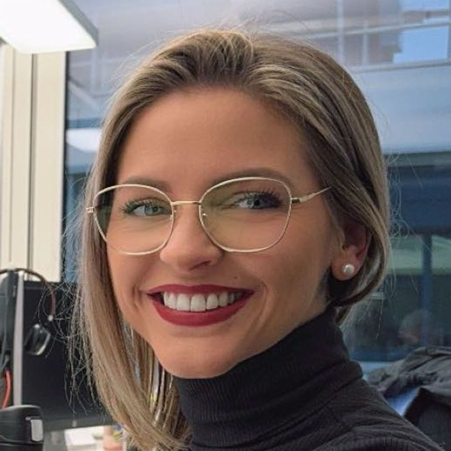 Genny Bollinger, specialist i gældssanering hos EOS i Schweiz, sidder ved sit skrivebord i en grå rullekravetrøje og smiler til kameraet.