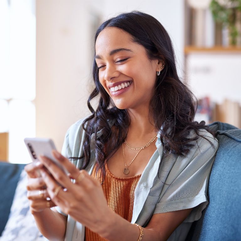 Woman sitting on a sofa and using smartphone