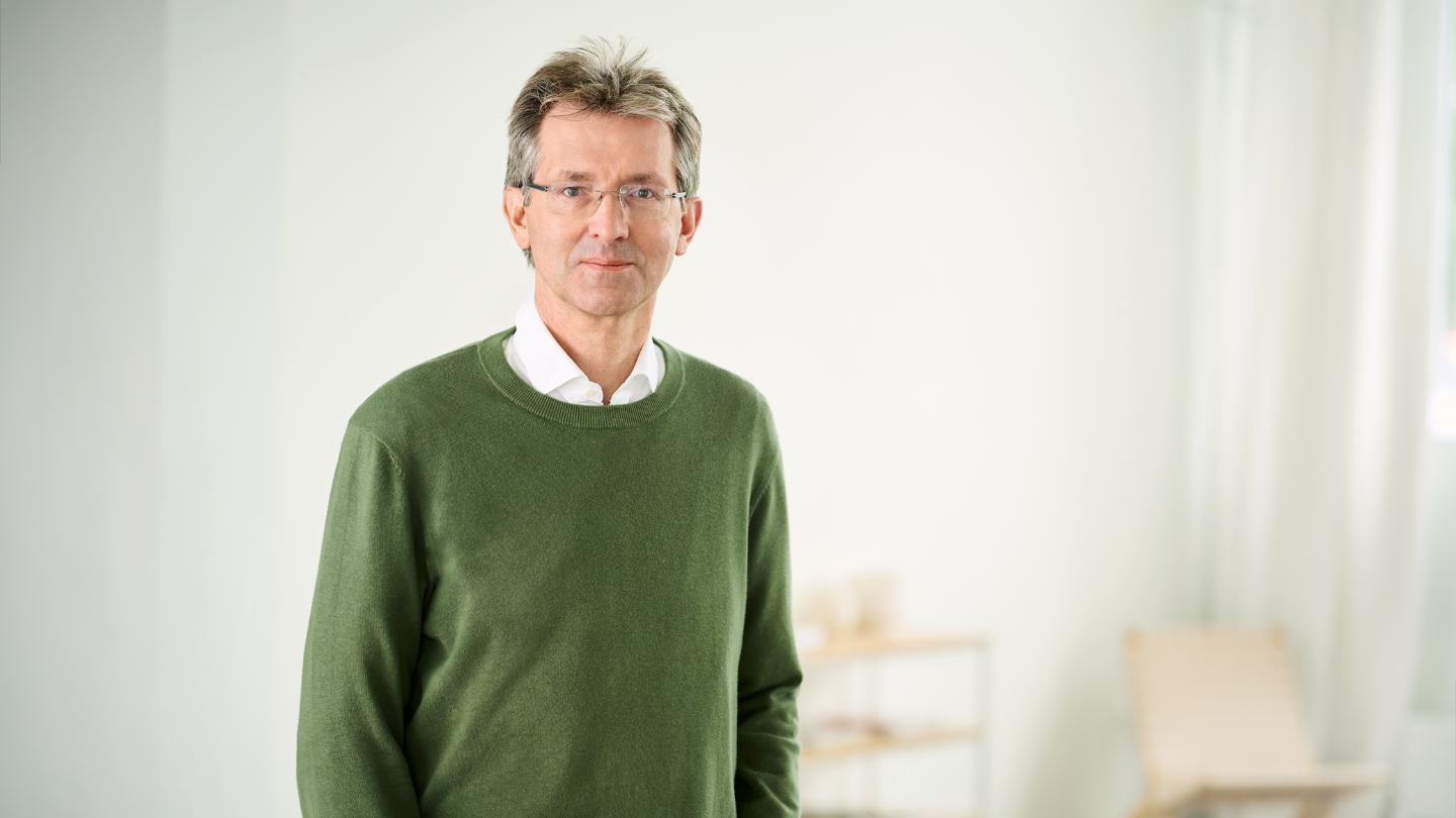 Justus Hecking-Veltman, CFO iført grøn pullover og hvid skjorte, står i et lyst lokale.