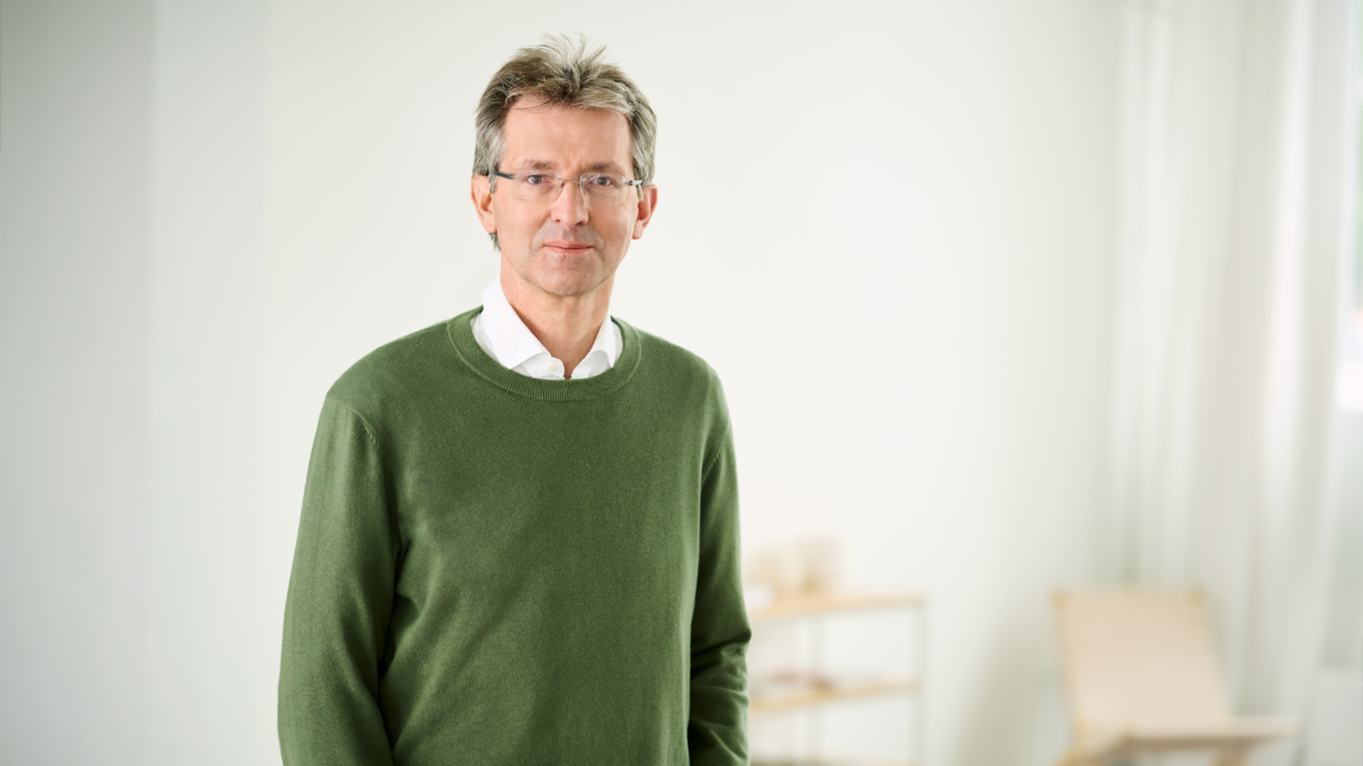 Justus Hecking-Veltman, CFO iført grøn pullover og hvid skjorte, står i et lyst lokale.